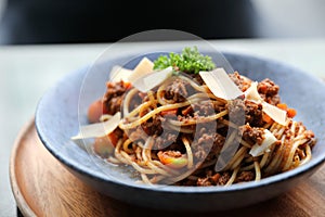 Spaghetti Bolognese with minced beef and tomato sauce garnished with parmesan cheese and basil , Italian food