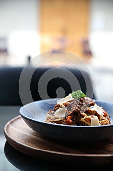 Spaghetti Bolognese with minced beef and tomato sauce garnished with parmesan cheese and basil , Italian food