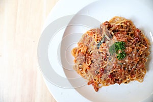 Spaghetti Bolognese with minced beef and tomato sauce garnished with parmesan cheese and basil , Italian food