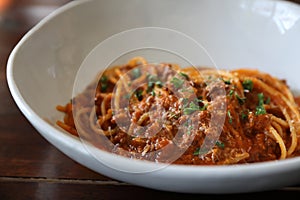 Spaghetti Bolognese with minced beef and tomato sauce garnished with parmesan cheese and basil , Italian food