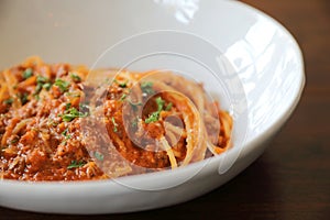 Spaghetti Bolognese with minced beef and tomato sauce garnished with parmesan cheese and basil , Italian food