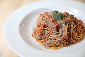 Spaghetti Bolognese with minced beef and tomato sauce garnished with parmesan cheese and basil , Italian food