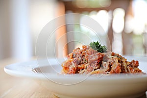 Spaghetti Bolognese with minced beef and tomato sauce garnished with parmesan cheese and basil , Italian food