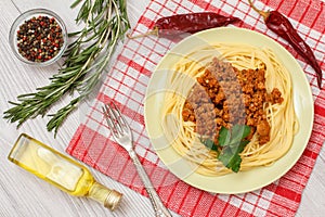 Spaghetti bolognese on a plate, spices and herbs with a napkin