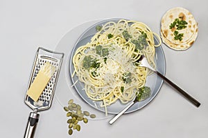 Spaghetti with broccoli paste and fork and spoon on ceramic plate