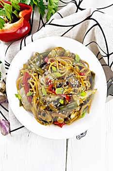 Spaghetti buckwheat with vegetables in plate on light board top
