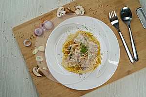 Spaghetti carbonara with fork and spoon and ingrediences