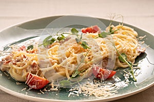 Spaghetti carbonara. pasta with bacon, creamy sauce, parmesan cheese and cherry tomato on plate