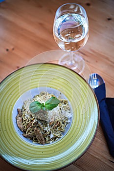 Spaghetti carbonara plate, with a glass of white wine