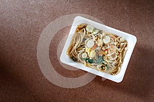 Spaghetti with chili pork basil leaf in food container.Top view.