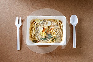 Spaghetti with chili pork basil leaf in food container.Top view.