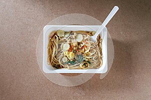 Spaghetti with chili pork basil leaf in food container.Top view.