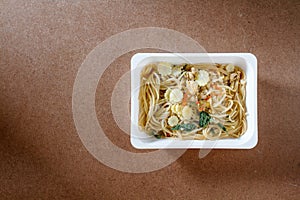 Spaghetti with chili pork basil leaf in food container.Top view.