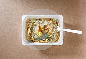 Spaghetti with chili pork basil leaf in food container.Top view.