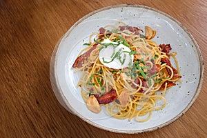 Spaghetti with crispy bacon and garlic and chilli topped with po