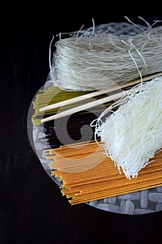 Spaghetti of different colours, bean noodles and rice paper
