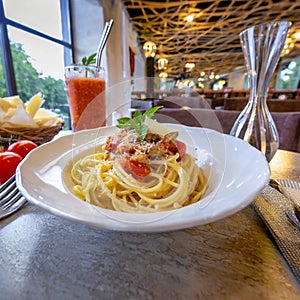 Spaghetti Elegance: Savory spaghetti with meat and tomato-garlic cream sauce, presented in a restaurant