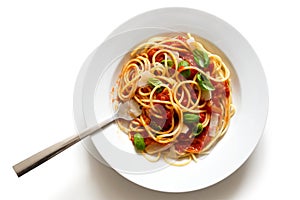 Spaghetti with fork, tomato sauce, fresh basil and cheese. Isolated on white from above.