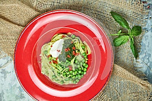 Spaghetti with fresh green peas. Gray textured background with beige fabric. Beautiful serving of dishes. Restaurant