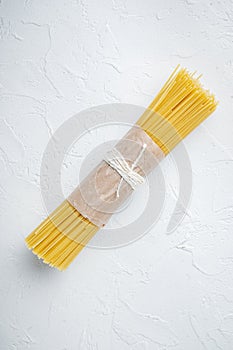 Spaghetti Italian Traditional Cuisine, dry and uncooked, on white background, top view flat lay