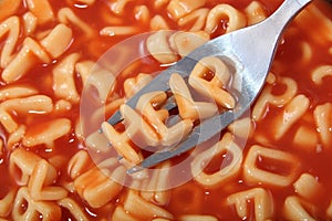 Spaghetti letter spelling the word help with the letters held up on a fork