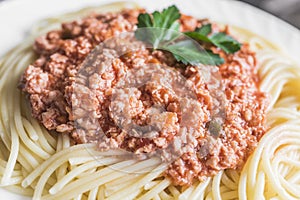 Spaghetti with meat sauce on white plate close up