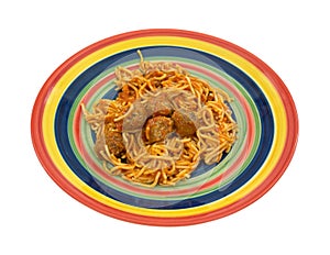 Spaghetti and meatball meal on colorful plate.