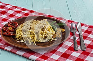 Spaghetti with mushrooms in cream sauce on a blue wooden background.