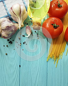 Spaghetti, oil healthy food preparatio dinner , vegetarian slow-motion garlic tomato black pepper on a blue wooden