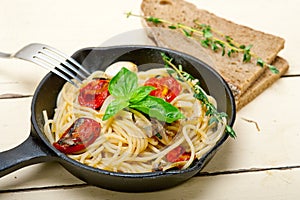 Spaghetti pasta with baked cherry tomatoes and basil