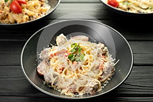 Spaghetti pasta with meatballs in creamy sauce with Parmesan cheese on a dark wooden background. Restaurant menu