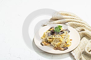 Spaghetti pasta with oyster mushrooms, creamy sauce and parsley. Healthy vegan food ready to eat