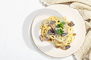 Spaghetti pasta with oyster mushrooms, creamy sauce and parsley. Healthy vegan food ready to eat