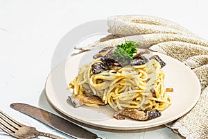 Spaghetti pasta with oyster mushrooms, creamy sauce and parsley. Healthy vegan food ready to eat