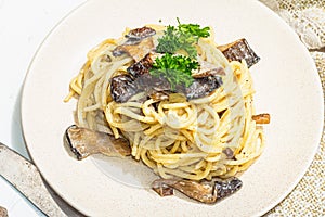 Spaghetti pasta with oyster mushrooms, creamy sauce and parsley. Healthy vegan food ready to eat