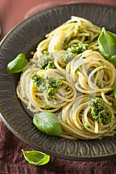 Spaghetti pasta with pesto sauce over rustic table