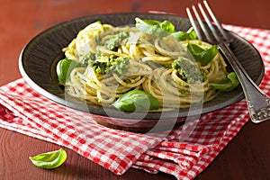 Spaghetti pasta with pesto sauce over rustic table