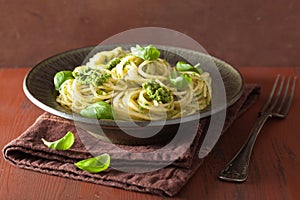 Spaghetti pasta with pesto sauce over rustic table