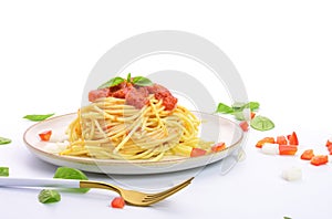 Spaghetti or pasta with tomato sauce and fresh green basil on a white plate with tomato isolated fork on a white background - top