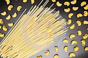 Spaghetti and pipe rigate Italian pasta. Dry pasta on black background