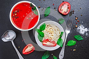 Spaghetti in a plate and tomato sauce in a small bowl with spices seasoning