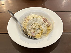 Spaghetti with red creamy chicken sauce and cheese served on a plate
