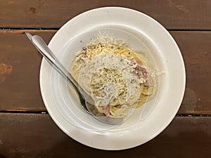 Spaghetti with red creamy chicken sauce and cheese served on a plate