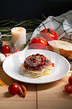 Spaghetti with red sauce on disk placing together with many recipes and candle