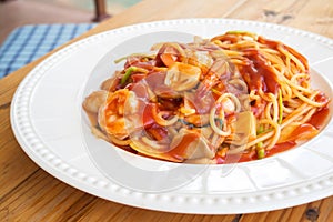 Spaghetti with red sauce and shrimp on white plate.
