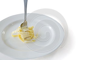 Spaghetti rolled up in fork with plate on white background