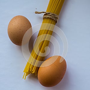 Spaghetti with a rope and eggs on white background