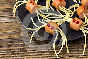 spaghetti with sausages in the form of spiders. Happy kid food for Halloween party