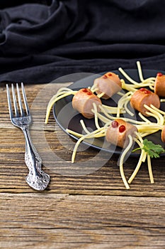 spaghetti with sausages in the form of spiders. Happy kid food for Halloween party