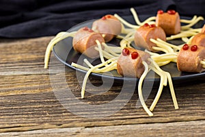 spaghetti with sausages in the form of spiders. Happy kid food for Halloween party. copyspace